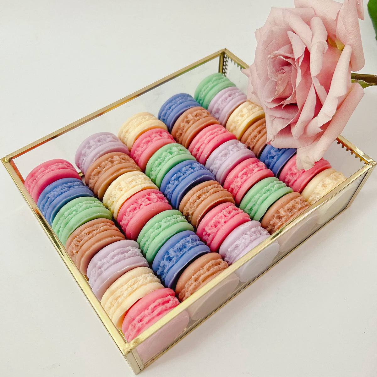 Six colorful macaron-shaped soy wax melts from LMJ Candles artistically arranged on ceramic warmer and cardboard box, showcasing eco-friendly and vegan features.