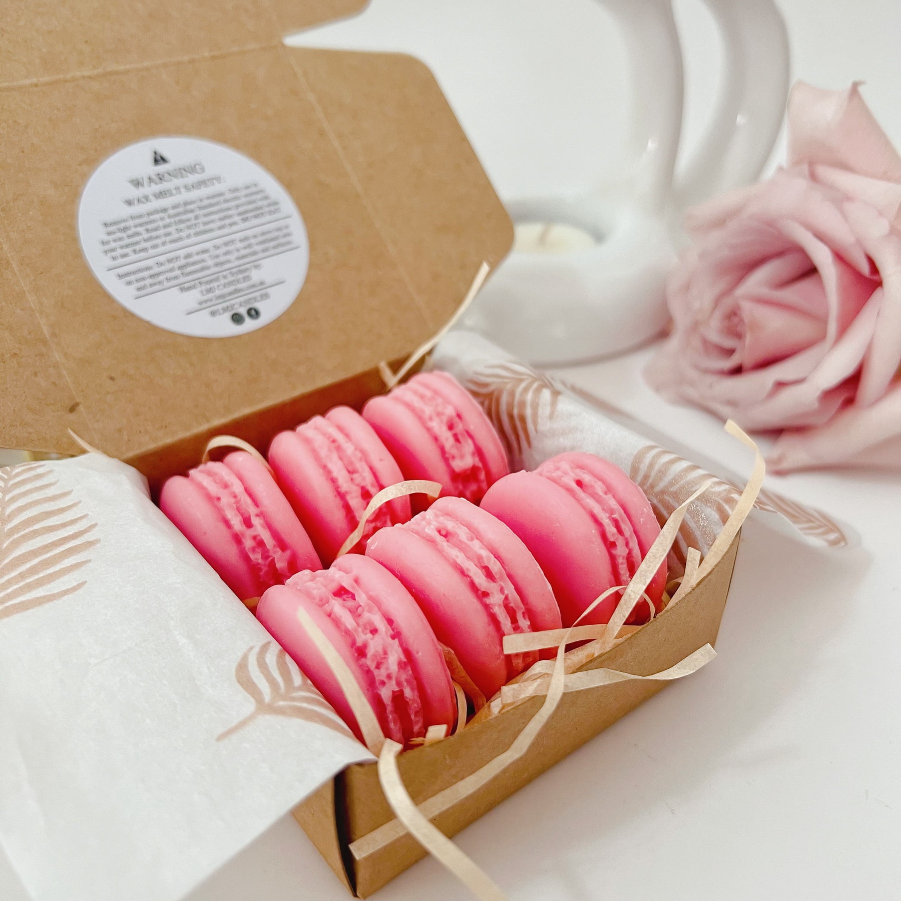 Six colorful macaron-shaped soy wax melts from LMJ Candles artistically arranged on ceramic warmer and cardboard box, showcasing eco-friendly and vegan features.