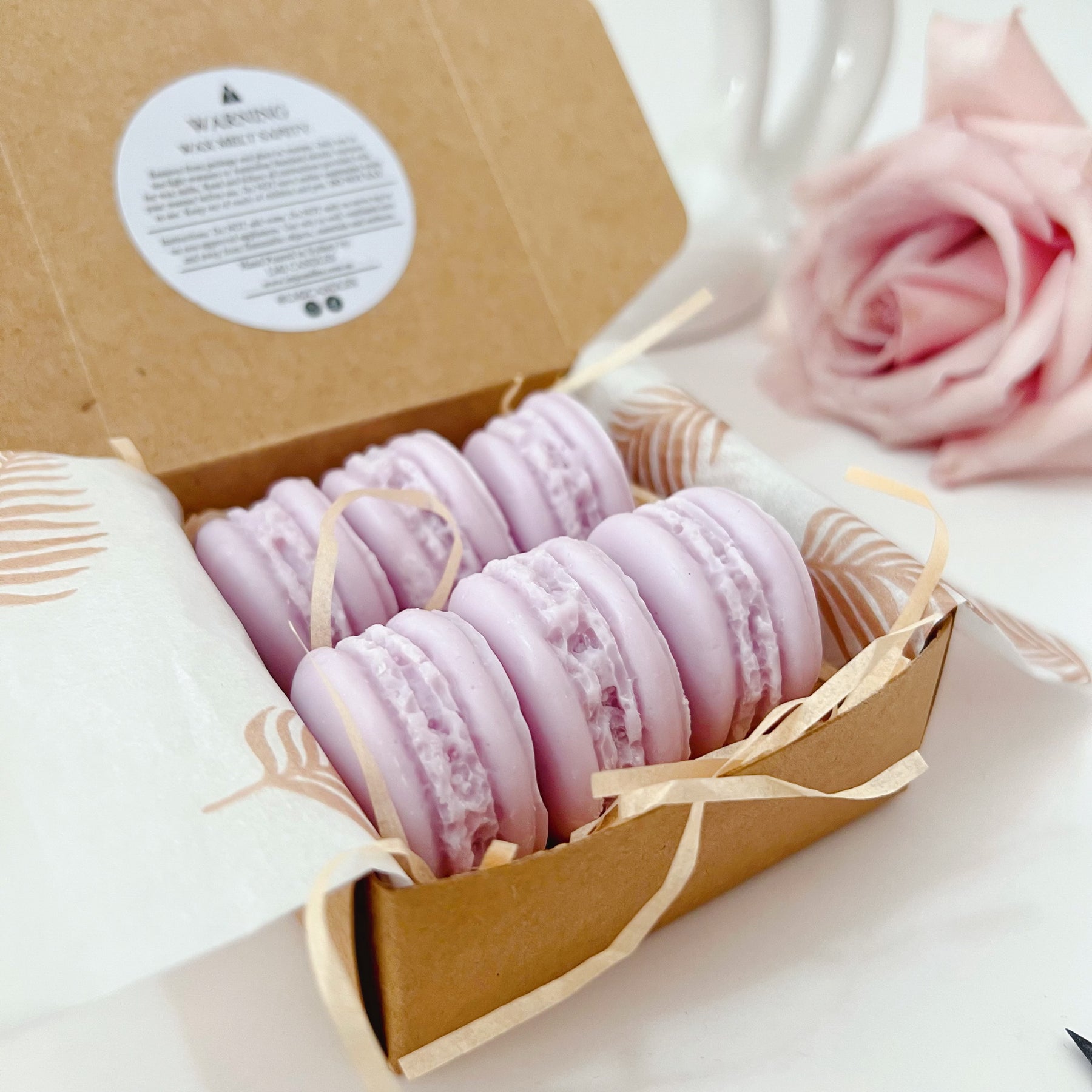 Six colorful macaron-shaped soy wax melts from LMJ Candles artistically arranged on ceramic warmer and cardboard box, showcasing eco-friendly and vegan features.