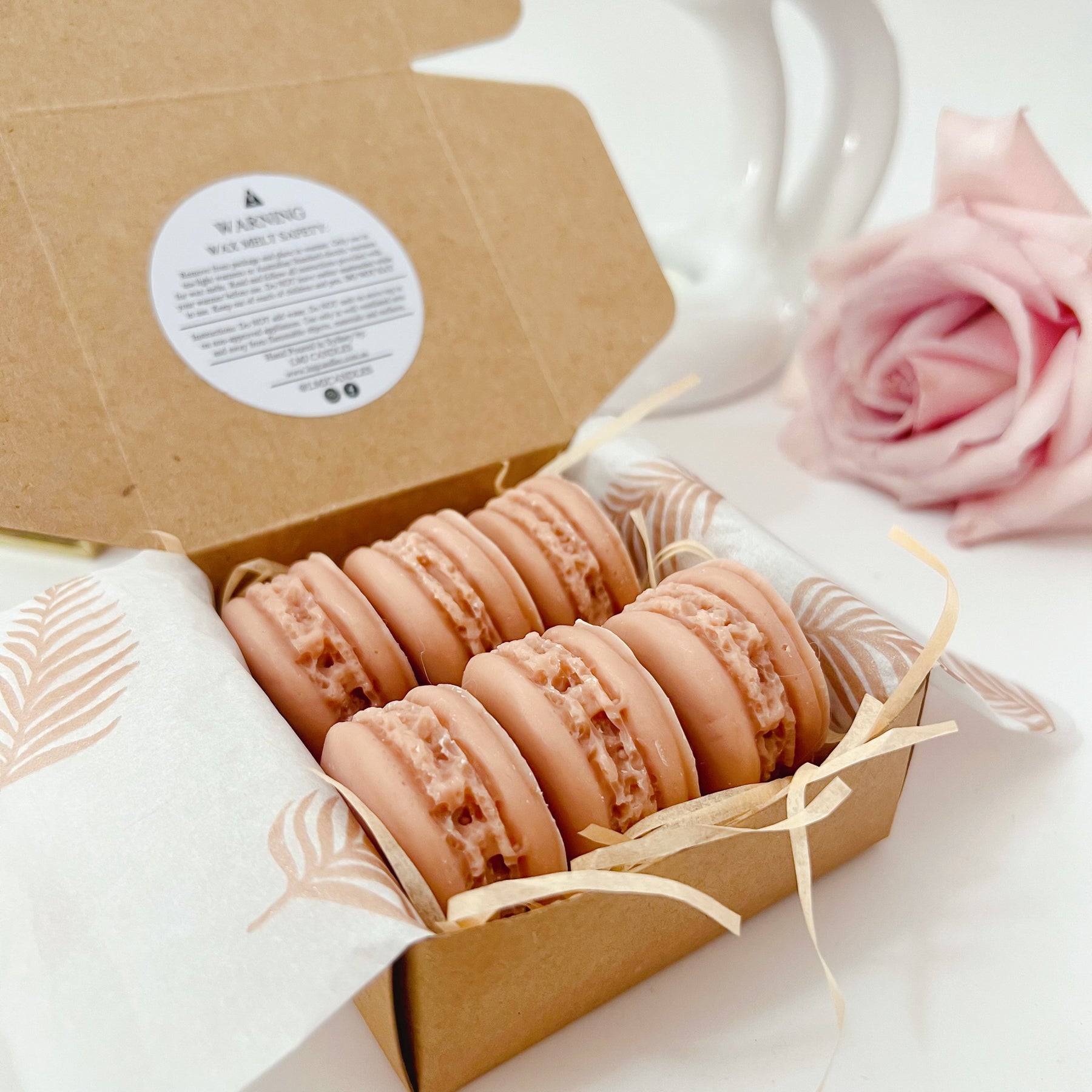 Six colorful macaron-shaped soy wax melts from LMJ Candles artistically arranged on ceramic warmer and cardboard box, showcasing eco-friendly and vegan features.