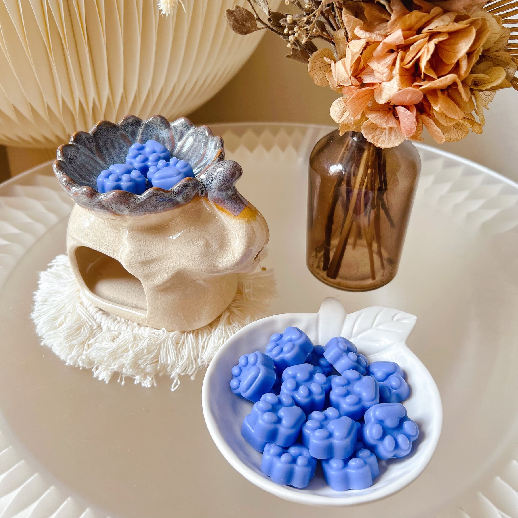 Pack of 20 cute paw-shaped soy wax melts from LMJ Candles displayed on a decorative tray and elephant shaped wax warmer, highlighting the eco-friendly and vegan qualities.