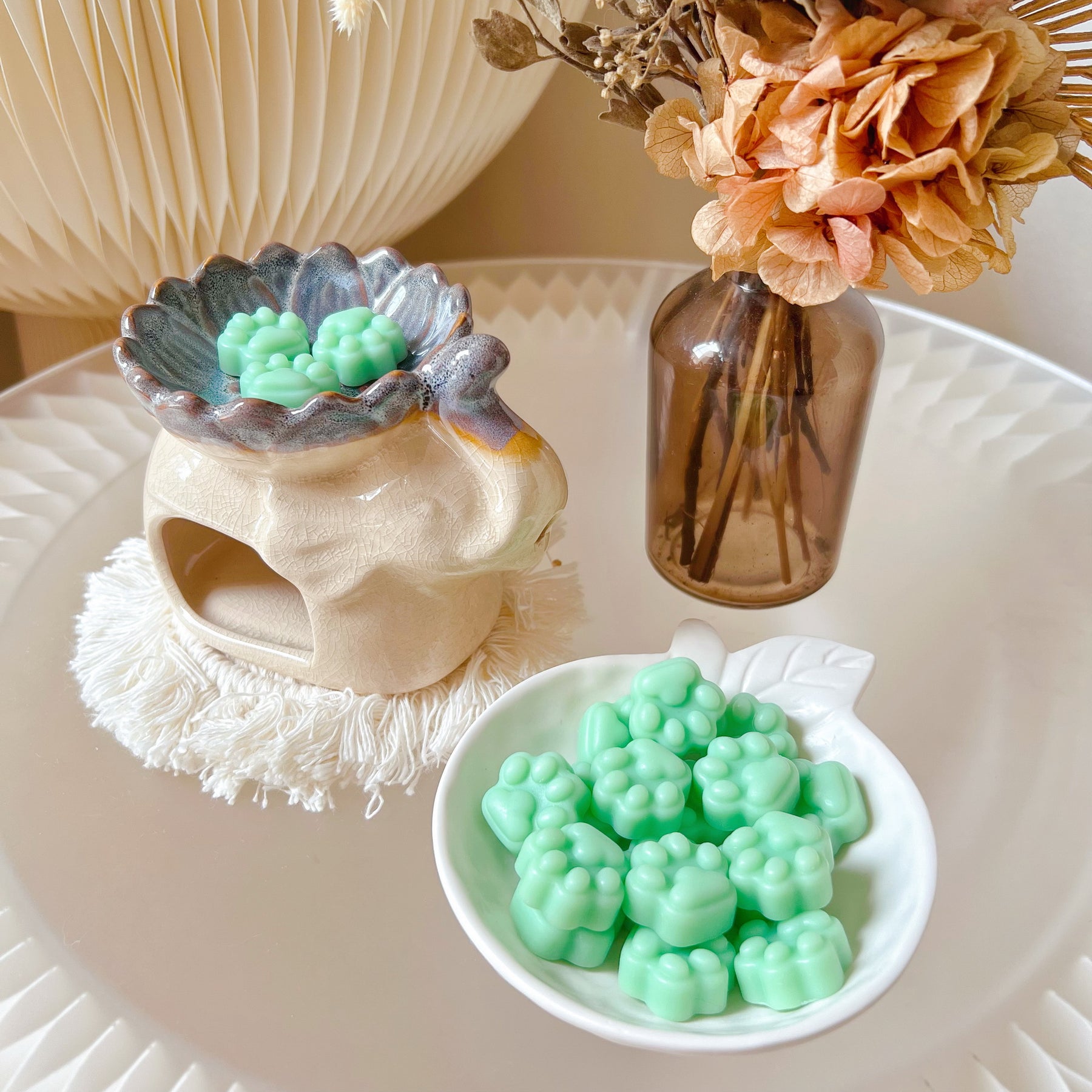 Pack of 20 cute paw-shaped soy wax melts from LMJ Candles displayed on a decorative tray and elephant shaped wax warmer, highlighting the eco-friendly and vegan qualities.