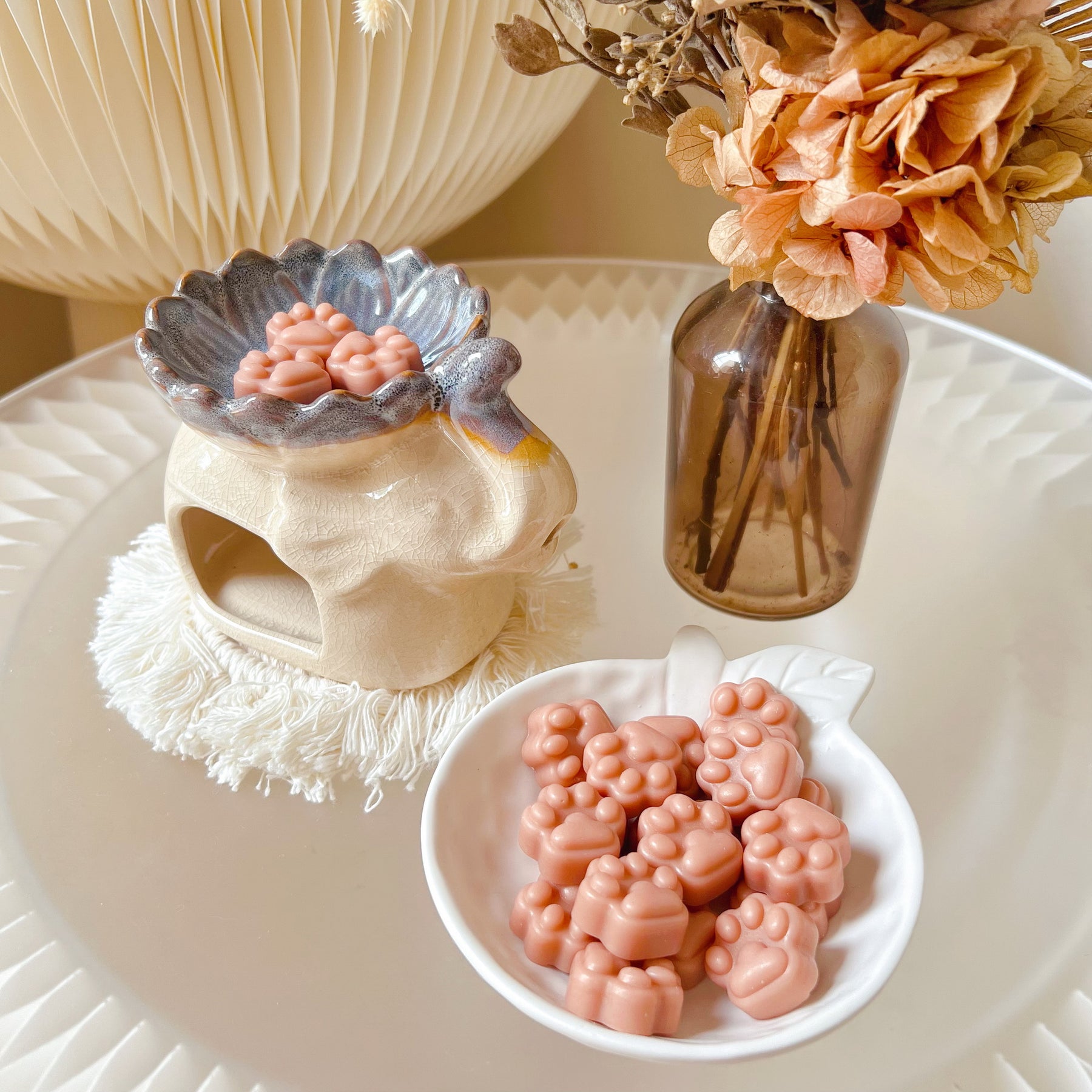 Pack of 20 cute paw-shaped soy wax melts from LMJ Candles displayed on a decorative tray and elephant shaped wax warmer, highlighting the eco-friendly and vegan qualities.