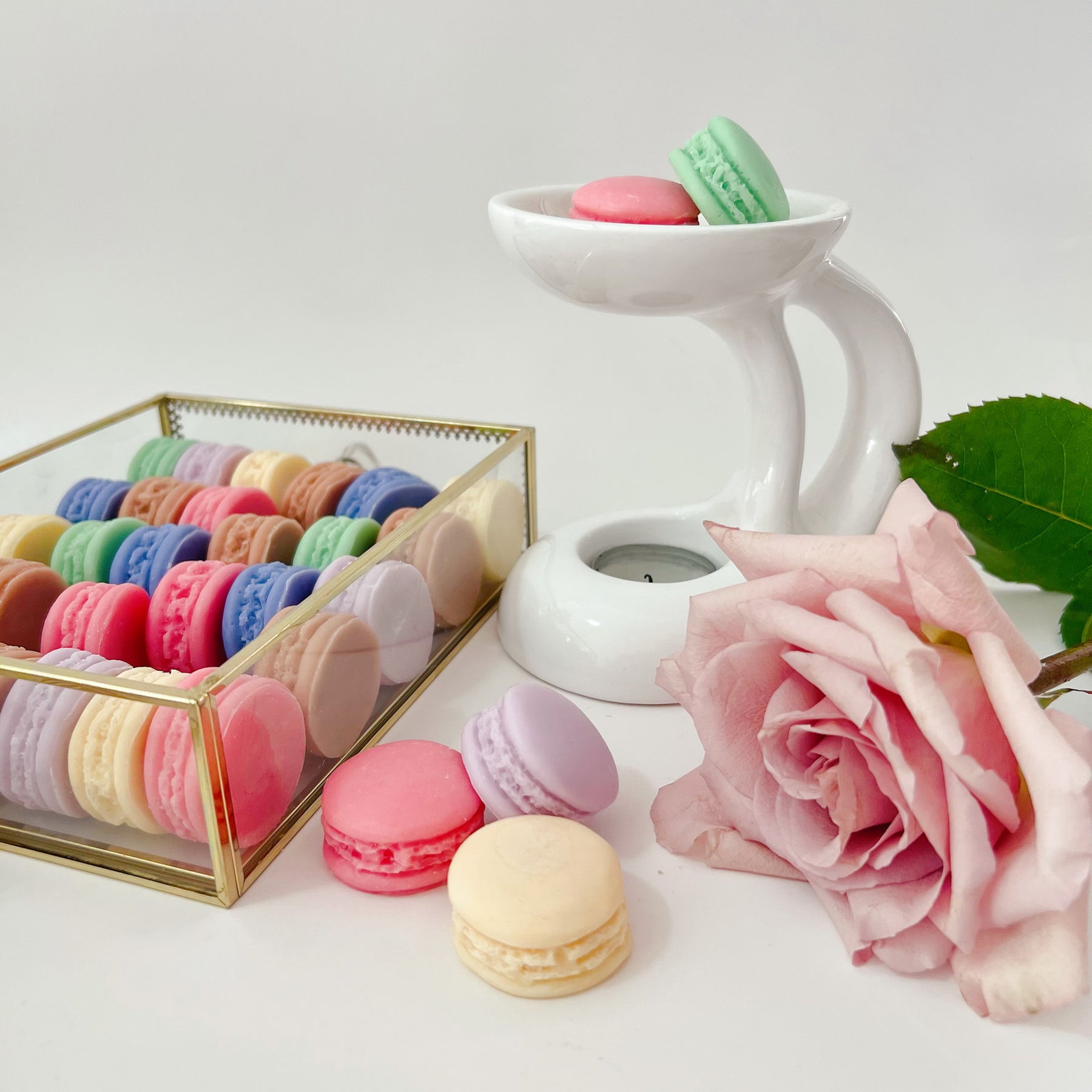Six colorful macaron-shaped soy wax melts from LMJ Candles artistically arranged on ceramic warmer and cardboard box, showcasing eco-friendly and vegan features.