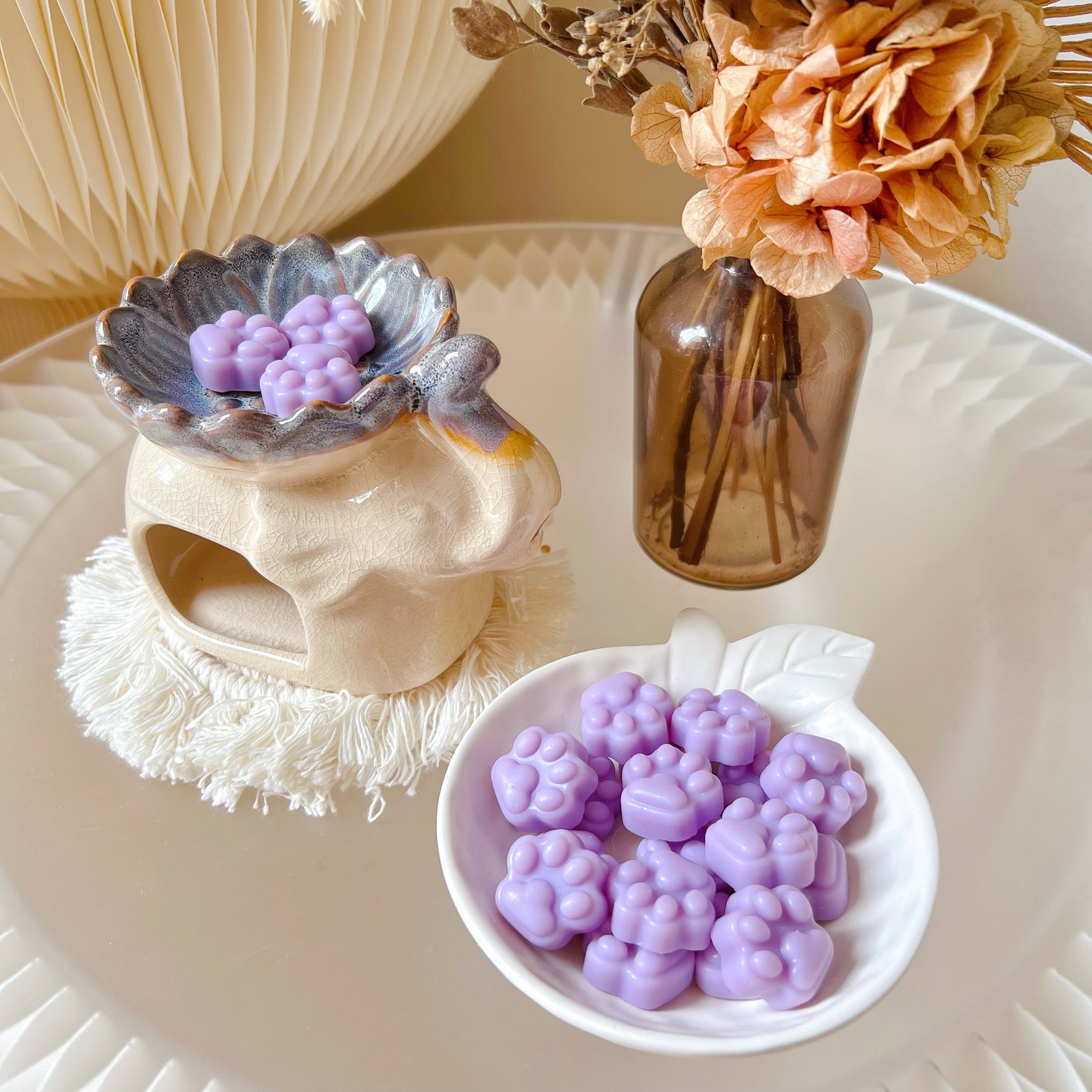 Pack of 20 cute paw-shaped soy wax melts from LMJ Candles displayed on a decorative tray and elephant shaped wax warmer, highlighting the eco-friendly and vegan qualities.