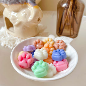 Pack of 20 cute paw-shaped soy wax melts from LMJ Candles displayed on a decorative tray and elephant shaped wax warmer, highlighting the eco-friendly and vegan qualities.